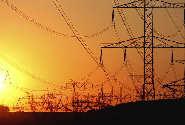 transmission tower   against the sun during sunset