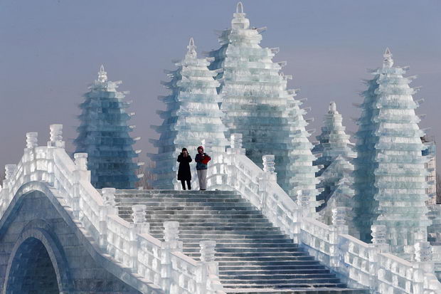 Visitors walk around ice sculptures during the annual ice festival in Harbin, Heilongjiang province