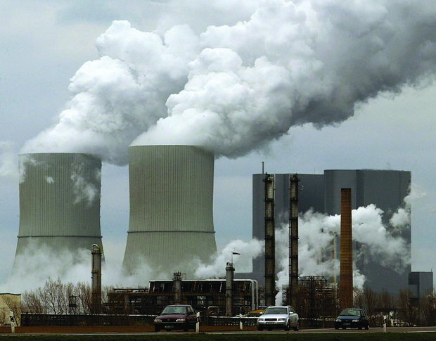 CARS DRIVE PAST A CHEMICAL PLANT NEAR THE EASTERN GERMAN VILLAGE OF LIPPENDORF